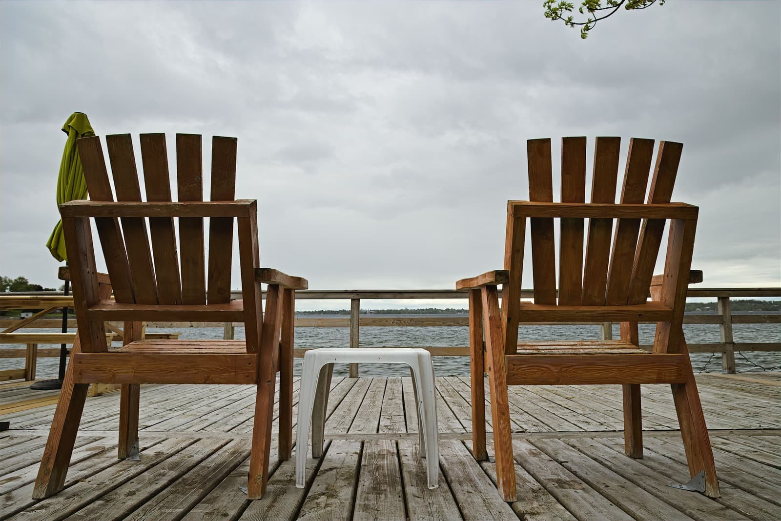 Adirondack chairs facing a lake at dusk